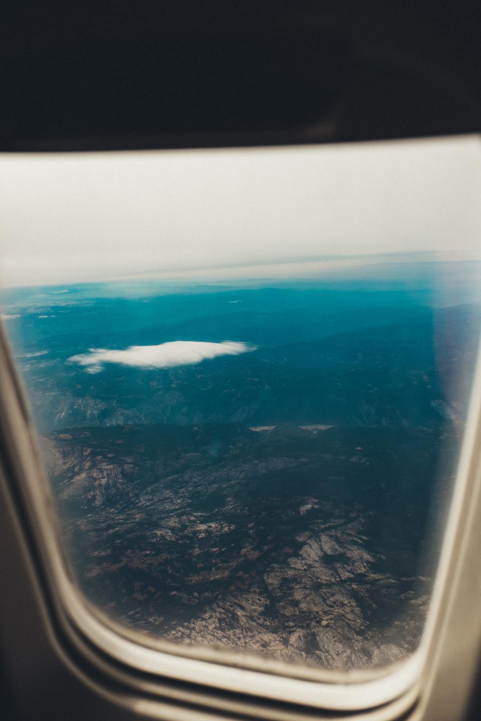 A view of mountains and clouds through an airplane window