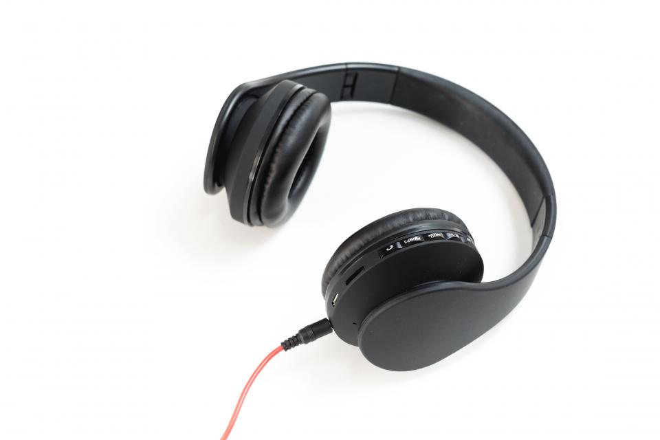 Black headphones with a red cable on a white background