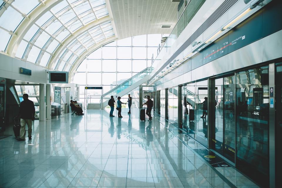 Travelers with luggage in a bright airport terminal
