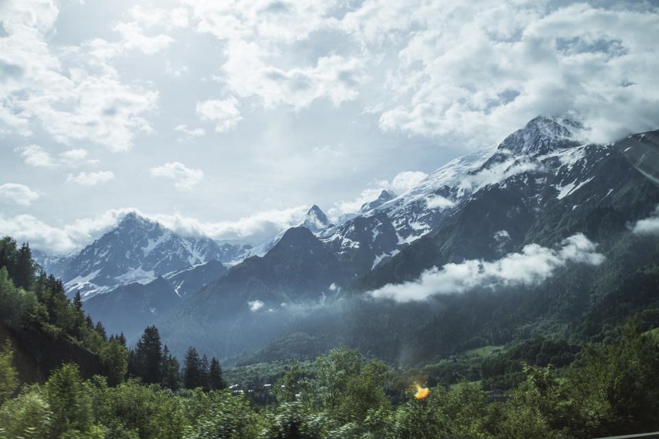 Snow capped mountain peaks rising above a green valley
