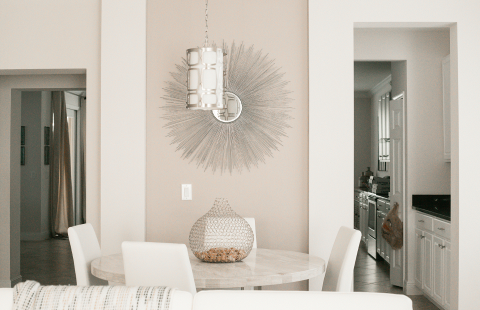 A styled dining room with a round table and pendant light